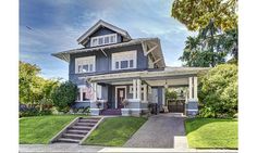 a large house that is painted blue and has stairs leading up to the front door