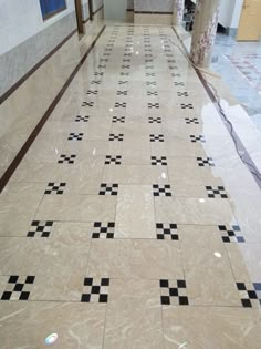 an empty hallway with black and white tiles on the floor