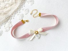 This romantic choker necklace is handmade with a soft blush pink double sided velvet ribbon. It features a vintage lace ribbon bow, pearl beaded jewel, and a beautiful vintage mother of pearl heart charm. A lovely gift for women who love to wear unique jewelry.  See last photos showing coordinating necklaces! This necklace is also available in blue, white and black velvet... sold separately in the Rosy Posy Designs shop. * Size ~ Adjustable length 12 - 15 inches with extender chain  Please check Vintage Ribbon Choker As A Gift, Vintage Ribbon Choker As Gift, Elegant Ribbon Choker As Gift, Ribbon Choker Necklace For Weddings, Adjustable Wedding Choker For Valentine's Day, Pink Ribbon Wedding Jewelry, Feminine Adjustable Ribbon Jewelry, Elegant Wedding Choker For Valentine's Day, Elegant Wedding Choker With Ribbon