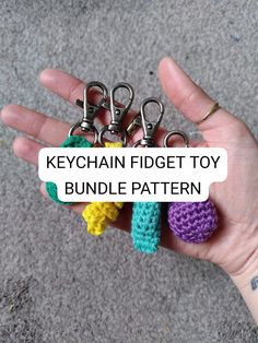 a hand holding several crochet keychain fidgets