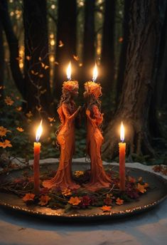 two candles in the shape of angels on a plate