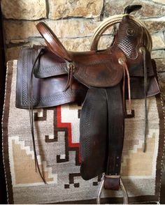 a brown saddle sitting on top of a rug