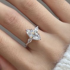 a woman's hand with a diamond ring on it