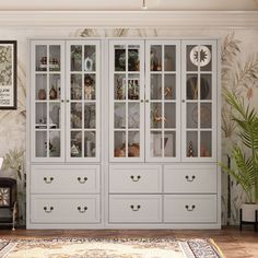 a large white china cabinet with glass doors and drawers in a living room next to a potted plant