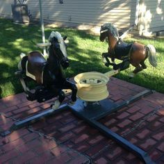 two toy horses on top of a brick patio