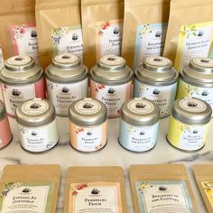 many different types of candles are on display in front of brown paper bags and packages