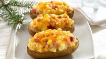 three baked potatoes topped with ham and cheese