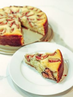 a piece of cake on a plate next to the rest of the cake, with one slice missing