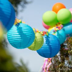 many colorful paper lanterns hanging from a tree