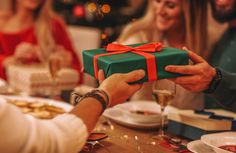 people sitting at a table with food and presents