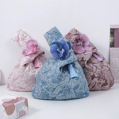 three bags with flowers on them are sitting next to a box and some other items