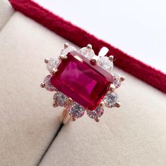 a ring with a large red stone surrounded by smaller white stones