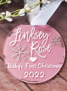 a baby's first christmas ornament hanging from a tree