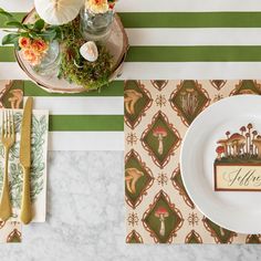 a place setting with plates, utensils and flowers