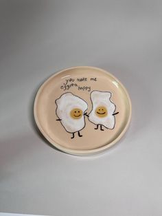 two fried eggs on a plate with the words you make me happy