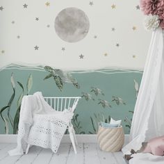 there is a white chair in front of a wall with stars and plants on it