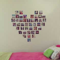 a heart shaped wall hanging over a bed with pink sheets and pillows on top of it