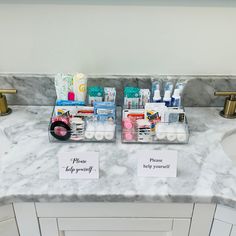 two bathroom sinks with personal care items on the counter top and in front of them