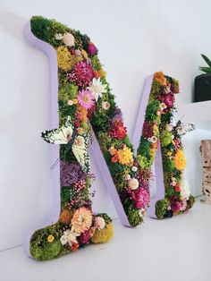 the letter m is made up of flowers and grass