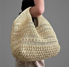 a woman carrying a large crocheted bag on her back with the handles down