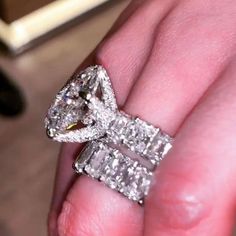 a woman's hand holding an engagement ring