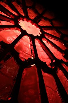 a stained glass window with red light shining through it