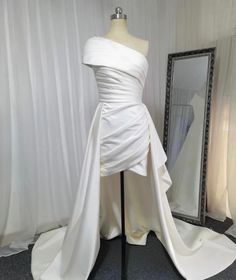 a white dress on display in front of a mirror