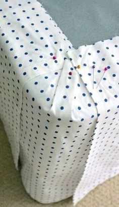 a white box with blue polka dots on it sitting on the floor next to a carpet