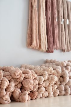 several skeins of yarn sitting on the floor in front of a white wall