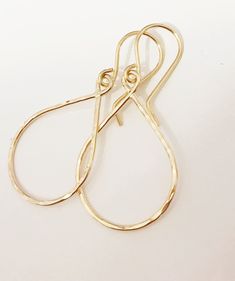 "Sleek and petite tear drop shaped hoops suspended from gold filled ear wires. Tear drop hoops is handmade with precious metal wire then hammered to textures and shine. Hoops is measure about 3/4\" x 1 inches in sizes. Hand shaped gold filled French ear wires." Dainty Teardrop Earrings With 14k Gold Filled, Dainty 14k Gold-filled Teardrop Earrings, Gold Teardrop Earrings For Everyday, Everyday Gold Teardrop Hoop Earrings, Yellow Gold Teardrop Hoop Earrings With Ear Wire, Everyday Teardrop 14k Gold Filled Hoop Earrings, Dainty Hammered Teardrop Earrings, Minimalist Hammered Teardrop Jewelry, Hammered Teardrop Earrings