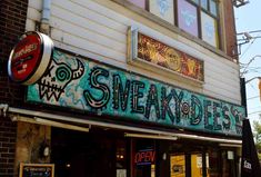 a building with graffiti on the side of it's front door and sign that says sneaky diners