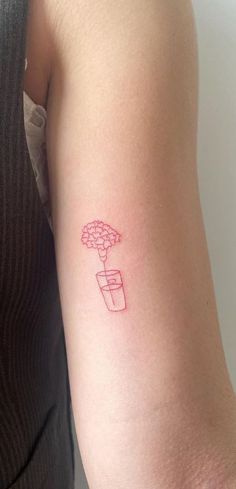 a woman's arm with a flower pot tattoo on the left side of her arm