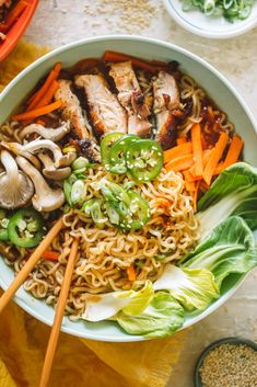 a bowl filled with noodles, meat and vegetables