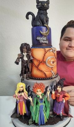 a man sitting in front of a halloween cake with figurines on the top