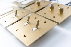 four metal plates with screws and rivets are arranged on a white surface