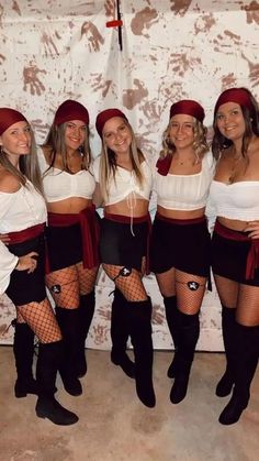 four women dressed in pirate costumes posing for a photo