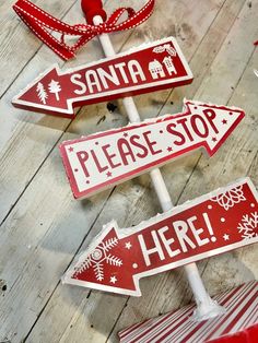 three red and white street signs sitting on top of a wooden floor next to each other