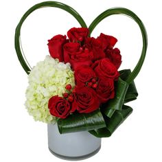 red roses and white hydrangeas in a heart shaped vase