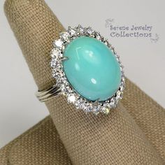 This unique light greenish blue turqoise is special in that it has not been stabilized but has kept color over the years. Brilliant round diamonds encircle the turquoise.Ring Size: 6.5Total Weight: 19.88 gramsPrecious Metal: 18k goldPrecious stones:-Sleeping Beauty Turquoise Center Stone: 18.1mm x 14.5mm-White Round Diamonds: 2 carats Luxury Turquoise Diamond Ring As Gift, Luxury Turquoise Diamond Ring, Formal Turquoise Diamond Ring With Gemstone, Blue Diamond Cabochon Ring, Blue Cabochon Diamond Ring, Blue Diamond Ring With Cabochon Cut, Formal Turquoise Diamond Ring, Luxury Turquoise Jewelry With Center Stone, Formal Fine Jewelry Turquoise Diamond Ring