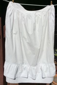 1900s french white cotton gathered full petticoat underskirt skirt with adjustable waist size monogram letters C B in red thread embroidered on the centre front waistband. The petticoat has a flounced hem and a straight dust ruffle which shows below the outer flounce.  The waist was made to be adjustable and extends from being 30 inches when the 2 tapes at the back are pulled fully in to 40 inches when the tapes are fully loosened. The waistband casing is in two parts one for each drawstring. Pu White Regency Style Petticoat With Ruffles, Daywear Tiered Gathered Petticoat, Daywear Tiered Skirt Petticoat With Ruffles, Daywear Ruffled Tiered Skirt Petticoat, Daywear Tiered Petticoat With Ruffles, Regency Style Ruffled Petticoat For Daywear, White Cotton Skirt With Attached Cancan, Cotton Petticoat With Gathered Skirt For Daywear, Daywear Ruffled Petticoat