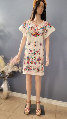 This Beautiful Mexican Colorful Floral Dress is the perfect dress for a fun night out or a special event. -It is full of colorful embroidered flowers and Tenango embroidered -This dress has ties on the back in order to adjust the fit. Hand embroidered. 100% artisanal Made in Mexico al ser bordado a mano.. todos los bordados son diferentes. Folk Style Multicolor Dress For Fiesta, Multicolor Folk Style Dress For Fiesta, Multicolor Folk Dress For Fiesta, Multicolor Cotton Dress For Cinco De Mayo, White Dresses For Cinco De Mayo Fiesta, Fiesta Cotton Embroidered Dress With Short Sleeves, Folk Style Dresses For Cinco De Mayo Festival, Short Sleeve Cotton Embroidered Dress For Fiesta, Embroidered Cotton Dress For Cinco De Mayo