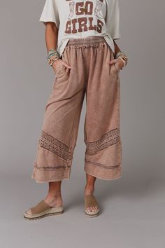 This boho - inspired pant, the Country Sunshine Crochet Wide Leg Pant, is perfect for lounging in comfort and boho style! What makes these pants so special is that they feature: Mineral washed, comfortable, knit fabric for a vintage, lived - in look Relaxed and loose silhouette for ultimate comfort Elastic drawstring waistband provides a comfortable and adjustable fit Wide pant legs with so cute crochet tape details Raw edges and exposed seams throughout for added boho style Side pockets for con Boho Relaxed Outfit, Modesty Journey, Styling Yoga Pants Outfits, Lounge Wear Outfit Ideas, Boho Clothes For Older Women, Boho Teacher Outfit, Boho Pants Outfit, Ward Robes, Earthy Clothes