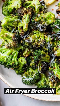 a white plate topped with broccoli covered in cheese