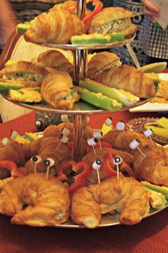 three tiered trays filled with croissants and pastries on top of each other