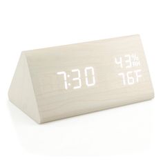 a wooden clock with white numbers on the front and back sides, sitting on a white surface