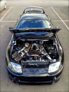 a car with its hood open in a parking lot