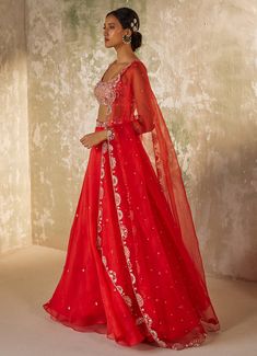 Unveil your inner elegance with the exquisite Red Embroidered Silk Organza Lehenga Set, a perfect blend of tradition and modernity. Crafted from pure silk organza, this ensemble features a red lehenga that exudes opulence through its all-over handwork motifs, adding a touch of luxury to every twirl. Paired with a delicately embroidered blouse, meticulously crafted with intricate aari handwork that showcases timeless artistry, the look is completed with a dupatta adorned with a heavily hand-embroidered border and motifs, elevating the ensemble to a new level of elegance. Perfect for a bride or bride-to-be on your special day, this outfit promises to make you the center of attention with its vibrant hue and breathtaking design. Composition : Dupatta & Lehenga - Pure Silk Organza, Blouse - Me Red Chanderi Lehenga With Resham Embroidery, Red Organza Sharara For Eid, Festive Sharara In Organza, Elegant Red Organza Saree, Red Organza Saree With Cutdana, Red Tissue Silk Lehenga For Festive Occasions, Red Organza Anarkali Set For Festive Occasions, Red Raw Silk Gown For Navratri, Red Organza Saree For Festive Occasions