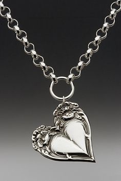 a silver necklace with a heart and angel on it