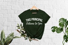 a green t - shirt that says, this principals believe in you on the front