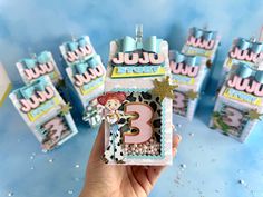 a hand holding up a birthday card with the number three on it and other decorations